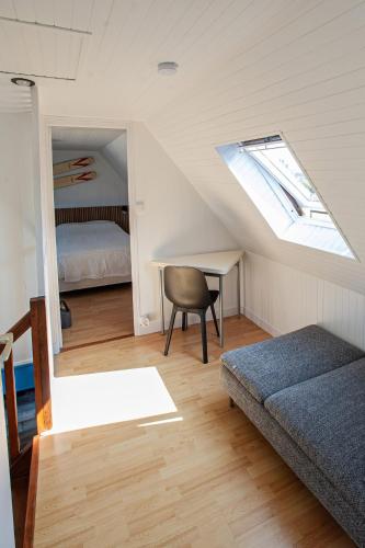 une chambre avec un lit et un bureau avec une fenêtre dans l'établissement Nice house with south-facing terrace, à Pleumeur-Bodou