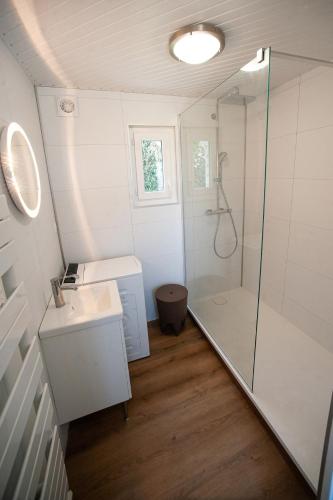 une salle de bain blanche avec une douche et un lavabo dans l'établissement Nice house with south-facing terrace, à Pleumeur-Bodou