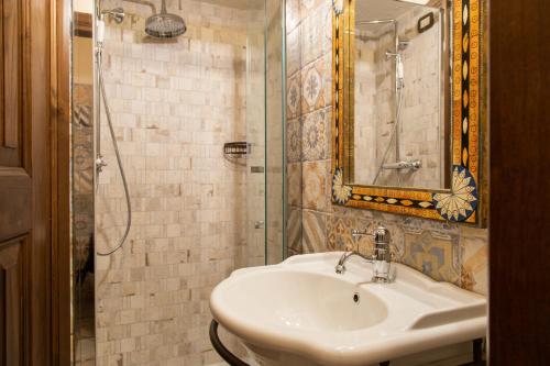 a bathroom with a sink and a shower with a mirror at Festina Lente - Guest House in Santo Stefano di Sessanio