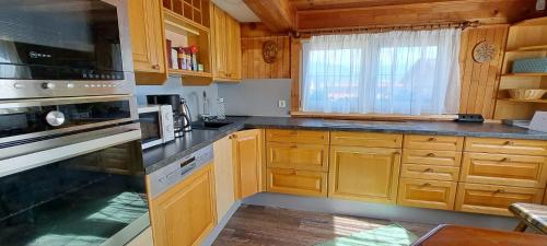 a kitchen with wooden cabinets and a stove top oven at Landruhe in Gimplach
