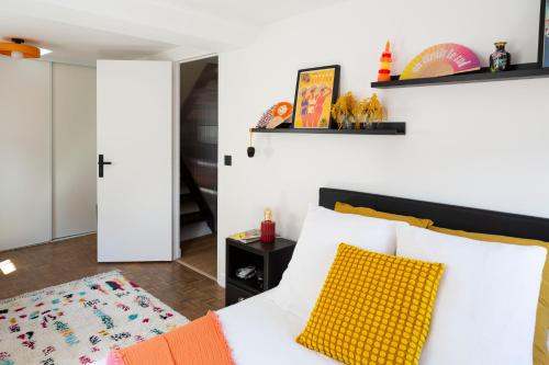 - une chambre avec un lit blanc et un oreiller jaune dans l'établissement Maison de ville moderne avec toit terrasse et vue, à Marseille