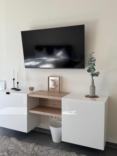 a white desk with a plant on a wall at Pier 1 bis 4 gmütliche Zimmer mit Boxspringbett in Cuxhaven