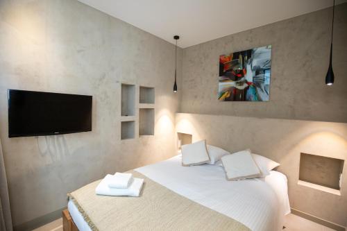 - une chambre avec un lit et une télévision murale dans l'établissement Modern 1-bedroom apartment with sea view on La Croisette, à Cannes