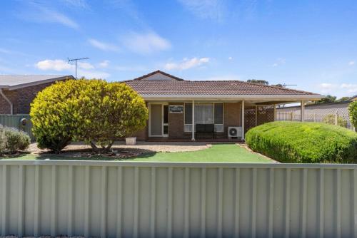 a house with a fence in front of it at Ardrossan Hotel Motel in Ardrossan