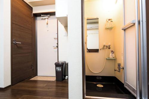 two images of a bathroom with a shower and a door at Central Shinjuku, Quiet Area, Close to Station, No Stairs, Room101 in Tokyo