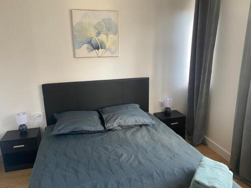 - une chambre avec un lit, 2 tables de chevet et une photo dans l'établissement Au toit de la cathédrale, à Sens