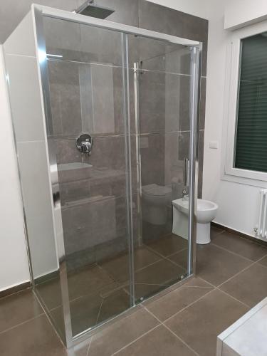 a glass shower in a bathroom with a toilet at CIVICO 14 Holiday Rooms in Suzzara