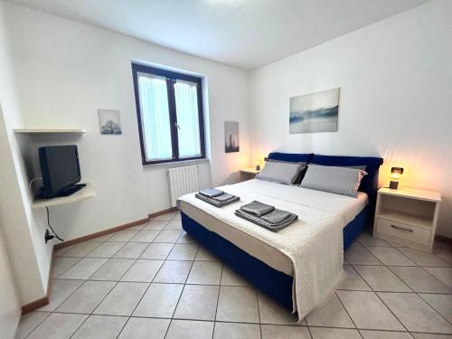 a bedroom with a large bed and a television at Casa Santi Il silenzio tra lago e montagna in Toscolano Maderno