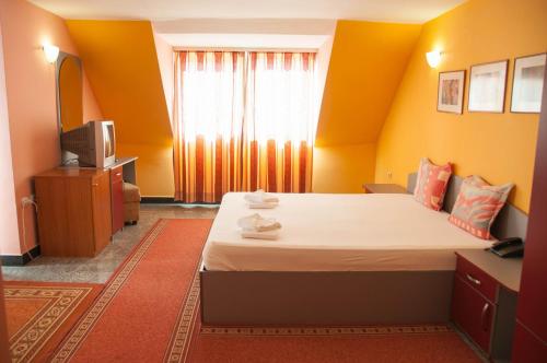 a hotel room with a bed and a television at Hotel Ertancom in Blagoevgrad