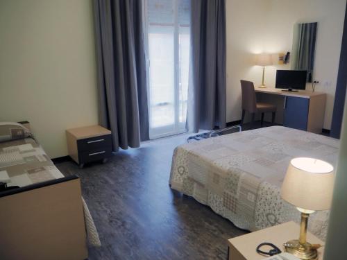 a hotel room with a bed and a desk with a computer at Hotel Ferrari in Chiavari