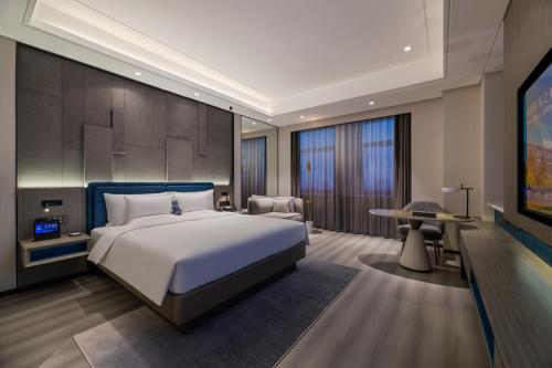 a bedroom with a large bed and a tv at Novotel Kunshan Yangcheng Lake in Kunshan