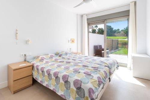 a bedroom with a bed and a large window at Apartamento bajo luxury golf Baviera Hills 54 in Caleta De Velez
