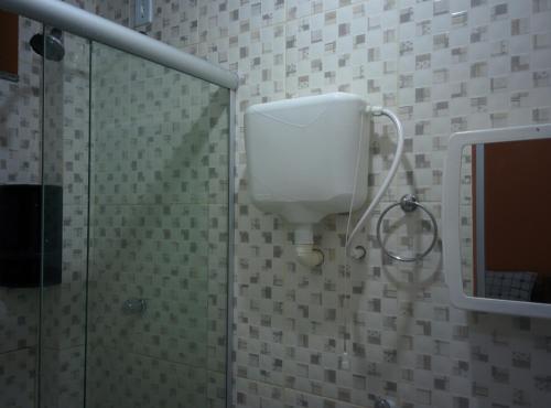 a bathroom with a shower stall with a white tank at Hotel Toraryca in Belém