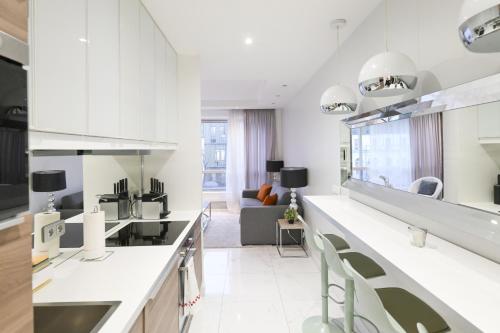 une cuisine avec des armoires blanches et un salon dans l'établissement Modern & peaceful 1BD APT by Champs-Elysees with AC, à Paris