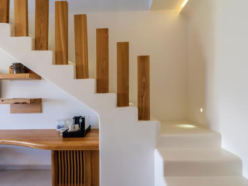 a room with a wooden table and stairs at Anax Resort and Spa in Agios Ioannis Mykonos