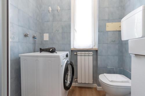 a bathroom with a washing machine and a toilet at Quadrilocale Ospedale Civile 8 , 3 Camere e due bagni in Brescia