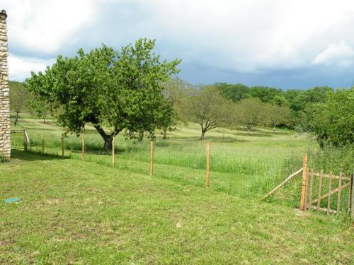 a fence in the middle of a field with trees at Gite brisset in Coulaures