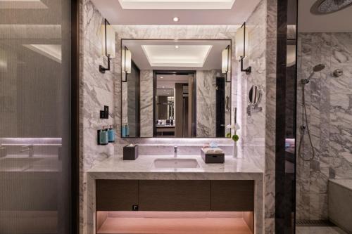 a bathroom with a sink and a mirror at Novotel Kunshan Yangcheng Lake in Kunshan