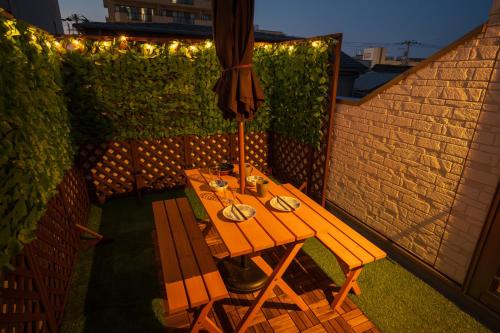 a wooden table on a patio with lights on it at New! U&I Villa close Disney & Narita AP - Great View in Tokyo