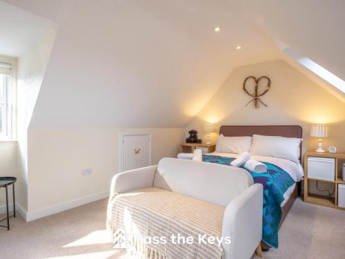 a bedroom with a bed and a chair at Cosy loft apartment near Oxford I Pass the Keys in Abingdon