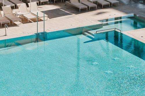 an overhead view of a swimming pool with chairs at Helios Mallorca Hotel & Apartments in Can Pastilla