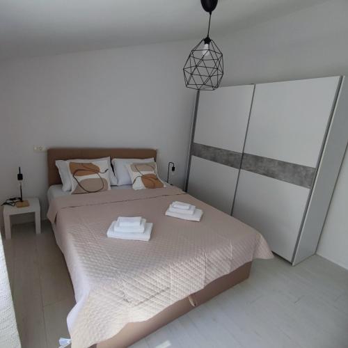 a bedroom with a bed with two towels on it at Apartman Đokić 3 in Bale