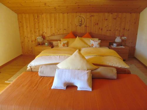 um quarto grande com uma cama grande com almofadas em Klampererhof em Virgen