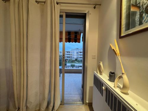 Cette chambre dispose d'une porte donnant sur un balcon. dans l'établissement 90 m2 Palm Beach apartment with 2 balconies Very stylish and central, à Cannes