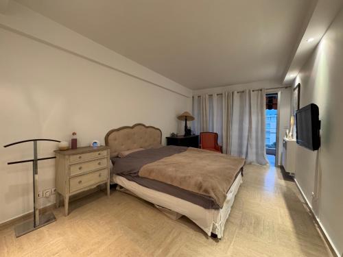 - une chambre avec un lit, une commode et une télévision dans l'établissement 90 m2 Palm Beach apartment with 2 balconies Very stylish and central, à Cannes