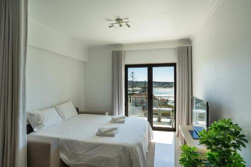 a bedroom with a bed and a view of the ocean at Sam's House in Foz do Arelho