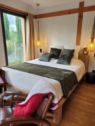 une chambre avec un grand lit et une grande fenêtre dans l'établissement La Cabane de Cinette, à Vallabrègues