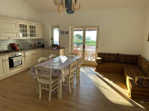 cocina con mesa, sillas y sofá en Villa Edith, en Parghelia