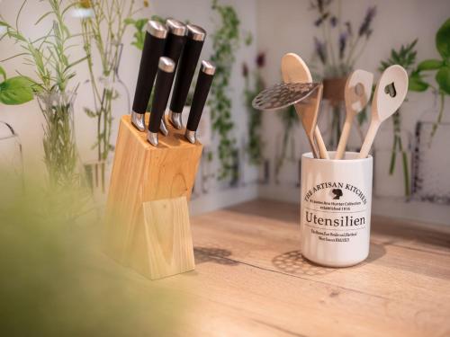 two wooden spatulas and a cup on a table at Ferienwohnung Pusteblume in Kappelrodeck