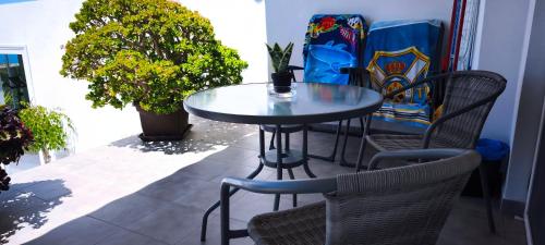 a glass table and chairs on a patio at Villa con increíbles vistas al océano y la Gomera in Chío