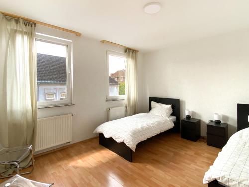 a bedroom with a bed and two windows at City Appartement in Gelsenkirchen