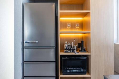 a kitchen with a stainless steel refrigerator and a microwave at L&R RUSUTSU - Vacation STAY 05027v in Kimobetsu