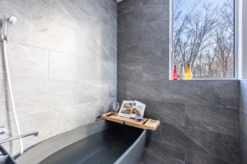 a bathroom with a bath tub and a window at L&R RUSUTSU - Vacation STAY 05027v in Kimobetsu