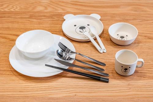 a table with plates and utensils with a teddy bear on it at L&R RUSUTSU - Vacation STAY 05027v in Kimobetsu