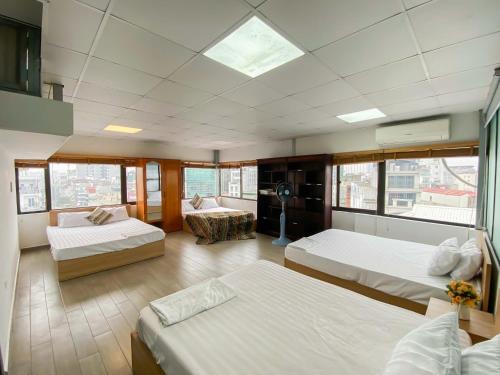 a large room with two beds and a living room at Eco Nest Apartment & Hotel Hai Bà Trưng in Hanoi