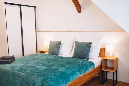a bedroom with a bed with a green comforter at Penzion Tlustá kachna in Chrudim