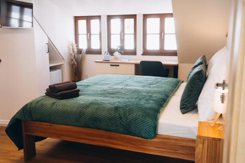 a bedroom with a bed with a green comforter at Penzion Tlustá kachna in Chrudim