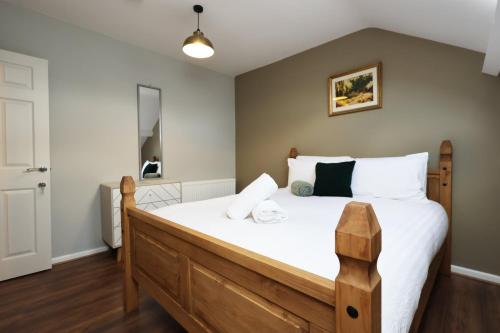 a bedroom with a large bed with white sheets at Modern Comfort 4 Bedrooms and Great Location in Cardiff