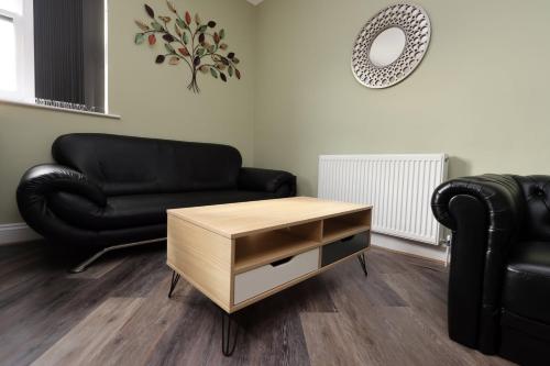 a living room with a couch and a coffee table at Modern Comfort 4 Bedrooms and Great Location in Cardiff