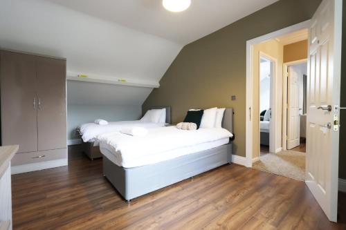 a bedroom with two beds with white sheets at Modern Comfort 4 Bedrooms and Great Location in Cardiff