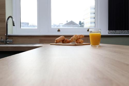 a table with a glass of orange juice and some pastries at Modern Comfort 4 Bedrooms and Great Location in Cardiff