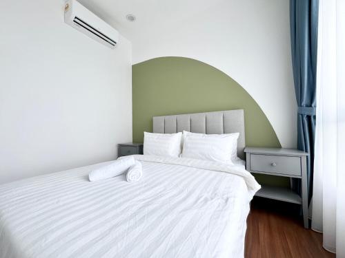 a bedroom with a white bed with two towels on it at Sunsuria Forum SOHO & Residence Suites Setia Alam by MOKA in Shah Alam