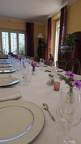 a long white table with glasses and flowers on it at Villa Monacelli in Fano