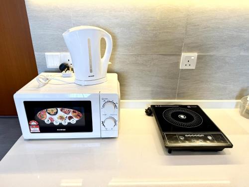 a microwave sitting on top of a counter with a blender at Sunsuria Forum SOHO & Residence Suites Setia Alam by MOKA in Shah Alam