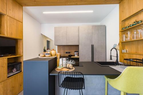 a kitchen with a counter with chairs in it at Gatto Matto in Brolo