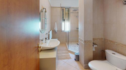a bathroom with a toilet and a sink and a shower at Coastal Nest Apartments in Durrës